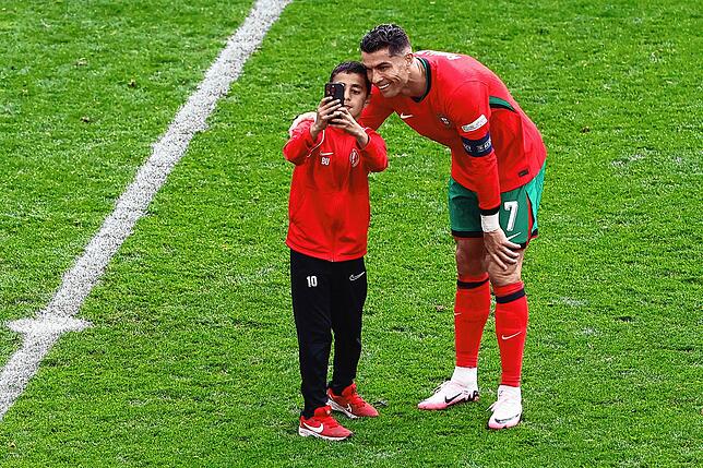 Cristiano Ronaldo freut sich über einen jungen Fan, der einen Schnappschuss mit seinem Idol haben will.