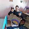 Gülsen Usta mit ihrer Tochter Elis, fünf Jahre, und dem 2-jährigen Diyan mit ihrem Regenbogen auf Pappe. Oben links steht der inzwischen ...