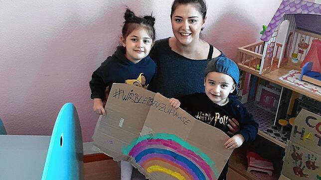 Gülsen Usta mit ihrer Tochter Elis, fünf Jahre, und dem 2-jährigen Diyan mit ihrem Regenbogen auf Pappe. Oben links steht der inzwischen ...