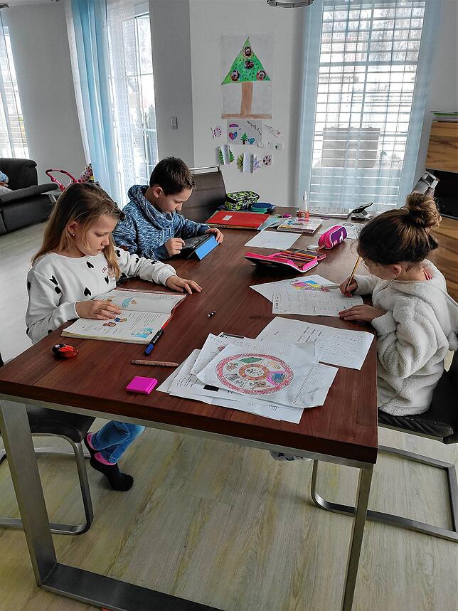 Schule zuhause ist der neue Alltag: Die Geschwister sitzen gemeinsam am Esstisch und lernen.