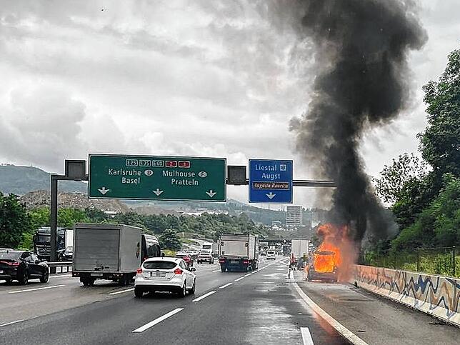 Ein brennendes Auto steht auf dem Pannenstreifen der A2 bei Augst.