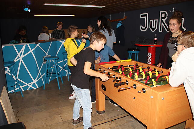 Nils Krause-Sittnick, Sabrina Anthis, Anthony Streit und Sören Bogenschütz spielen am Tischkicker.