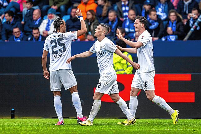 Freiburgs Kiliann Sildillia (l-r), Freiburgs Roland Sallai und Freiburgs Michael Gregoritsch jubelnnach dem Tor zum 0:2.