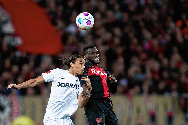 Leverkusens Victor Boniface (r) und Freiburgs Kiliann Sildillia kämpfen um den Ball.