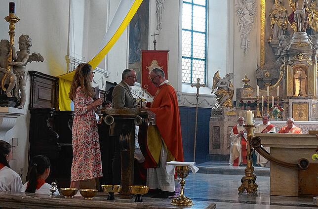 Ulrika Schirmaier (von links) und Klaus Bachmann vom Pfarrgemeinderat gegen Ende der Feier in der Liebfrauenkirche mit Pfarrer Ulrich ...