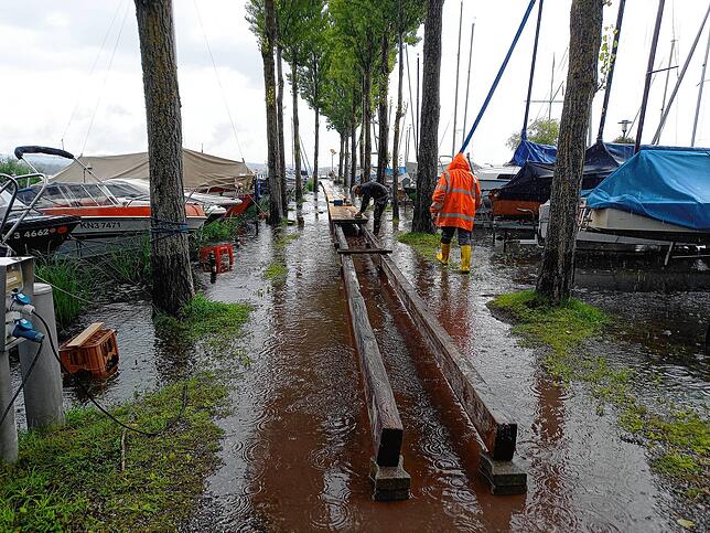 Wasser steigt: Mitarbeiter des Bauhofs bauen im Hafen in Moos einen Behelfssteg.
