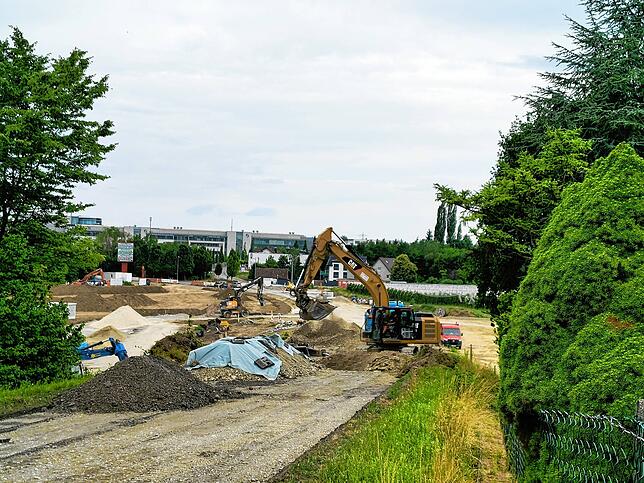 Tonnenweise Erde wird bewegt: Blick auf die Großbaustelle an der „Müllstraße“ von der Absperrung auf der Raderacher Seite aus.