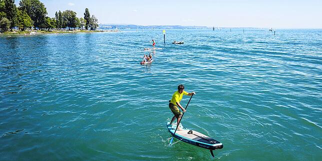 Stand-up-Paddler auf dem Bodensee vor dem Konstanzer Strandbad Horn. Wer außerhalb der Uferzone paddelt, muss eine Schwimmweste dabei haben.
