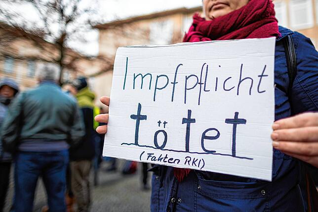 „Impfpflicht tötet (Fakten RKI)“ steht auf einem Schild, das eine Demonstrantin bei einer Kundgebung der AfD in Hannover hält.