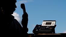 Ein Mann hält einen Telefonhörer in der Hand.