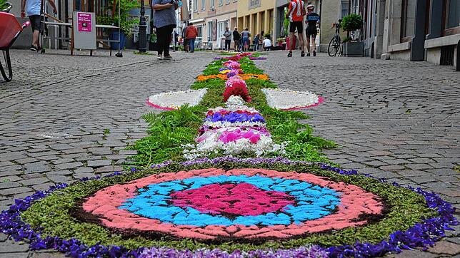 Der von den Trachten gelegte Blumenteppich in der Marktstraße erregt Aufmerksamkeit.