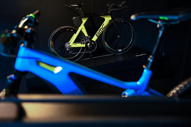 Das Rennrad Time Machine 01 TWO steht in der Messe in Friedrichshafen auf dem Stand des Herstellers BMC. Im Vordergrund ist der blaue ...