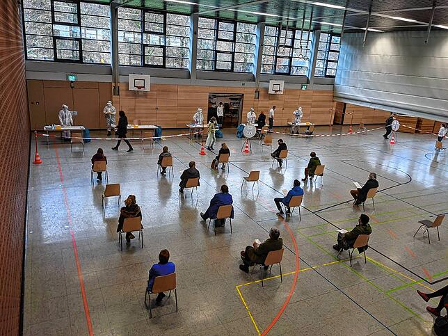 In der Stadthalle warten die Menschen, die sich testen lassen wollen, mit großem Abstand auf zugewiesenen Plätzen.