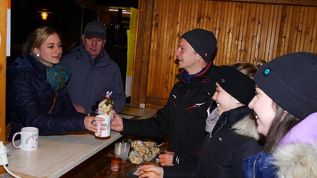 Jacqueline von Ow, Anna-Lena Haag und Rainer Hößler (von rechts) am Stand des Musikvereins Deggenhausen-Lellwangen geben Glühwein und ...