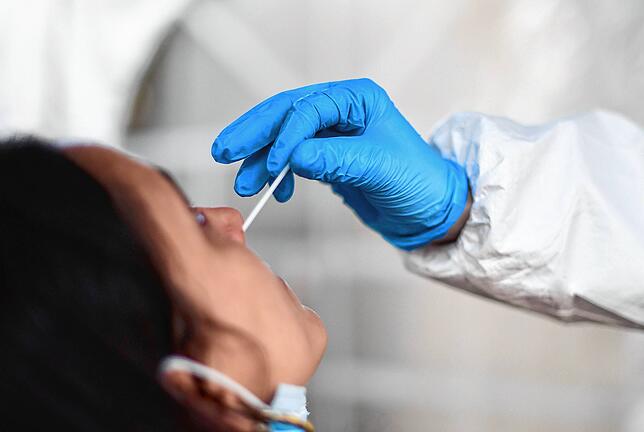 Eine Mitarbeiterin in einem Testzentrum entnimmt eine Probe aus dem Nasenraum für einen Coronatest. Solche Tests sollen auch weiterhin ...