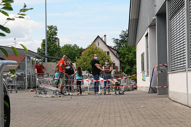 Strenge Einlasskontrollen bei einem Discounter in Jestetten. Kunden müssen draußen warten, bis im Laden genug Platz ist.