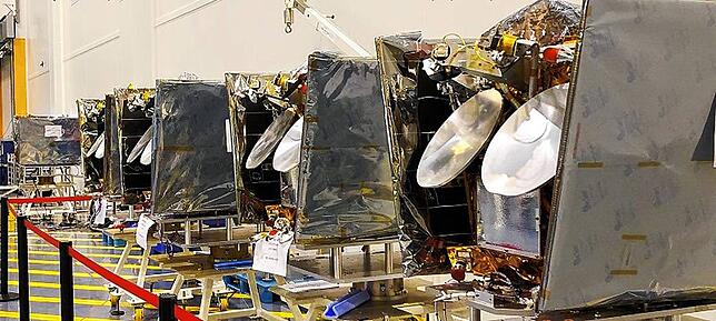 Mehrere OneWeb-Satelliten stehen vor der Verladung zum Flug ins All nebeneinander. OneWeb ist einer der hauptkunden von Space-Tech.