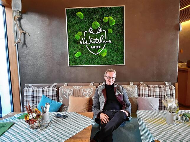 Reinhard Klumpp macht es sich auf der Sitzbank in seinem Restaurant s‘Wirtshaus gemütlich.
