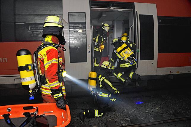 Die Retter erreichen den Einsatzort und holen die Passagiere aus dem Zug.