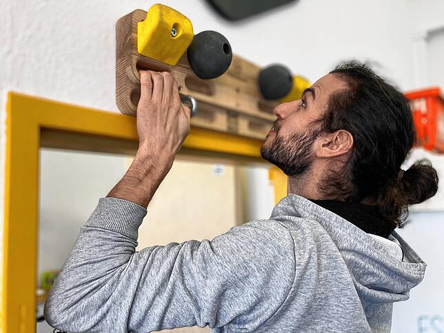 Adrian Flaig zeigt das Training am Polyboard über einem Türrahmen. Hier kann der Kletterer gezielt Griffe, Bewegungen und Muskelpartien ...