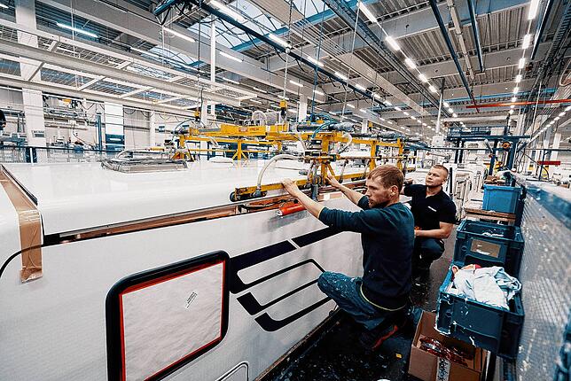 Diese beiden Hymer-Mitarbeiter beschäftigen sich mit dem Dach eines Wohnmobils.