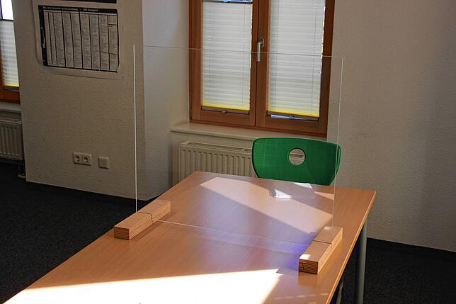 Plexiglas trennt zwei Arbeitsplätze in der Nachhilfeschule.