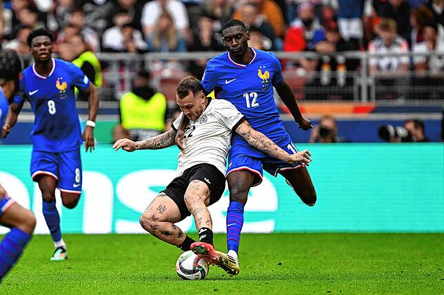 Deutschlands David Raum (l) und Frankreichs Randal Kolo Muani kämpfen um den Ball.