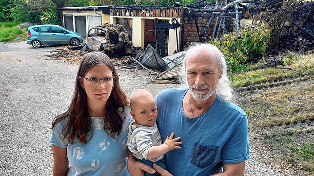 Aline Widmann mit ihrem Vater Clemens Oßwald, der ihren Sohn Gabriel auf dem Arm trägt, vor ihrer niedergebrannten Scheune im Lilienweg. ...