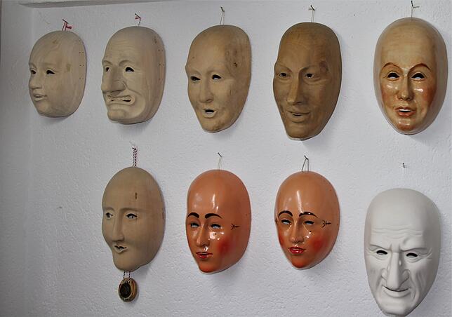 Viele Rohmasken in unterschiedlichen Bearbeitungsstufen hängen im Atelier von Elmar Dold.