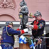 Die Katerfigur wird auf dem Brunnen aufgestellt, ein Ritual, das inzwischen zum zehnten Mal in der Niedere Straße stattfindet.