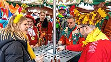 Emma Henne, Prinz Philipp, Joachim Müller und Bürgermeister Johannes Henne (am Tisch, von links) spielen &bdquo;Mäschkerle ärgere Dich ...