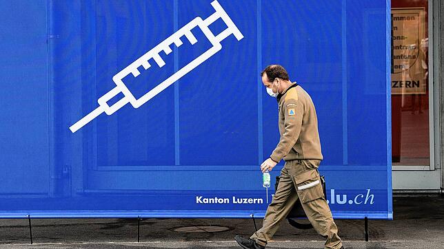 Ein Mann läuft vor einem Plakat mit einer Spritze am Haupteingang eines Impfzentrums in Luzern vorbei. Viele Vorteile können Geimpfte in ...