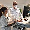 Hinrich Bremer und die examinierte Gesundheits- und Krankenpflegerin Laura Scapin besprechen anhand von Bildern am Monitor den ...