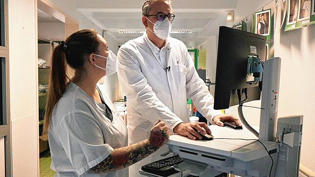 Hinrich Bremer und die examinierte Gesundheits- und Krankenpflegerin Laura Scapin besprechen anhand von Bildern am Monitor den ...