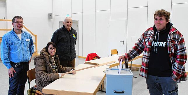 Miro Zimmermann steckt in der Ramsberghalle in Großschönach seinen Wahlschein in die Wahlurne unter den strengen Augen der Wahlhelfer ...