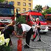 Der katholische Dekan Matthias Zimmermann nutzte zur Segnung der aufgereihten Fahrzeuge eine Feuerwehrkübelspritze. Bild: Elmaar Veeser