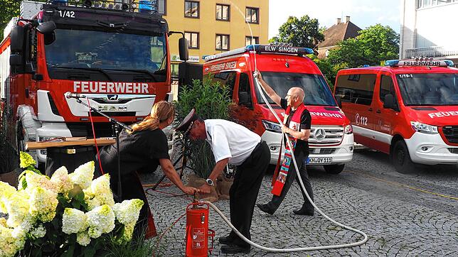Der katholische Dekan Matthias Zimmermann nutzte zur Segnung der aufgereihten Fahrzeuge eine Feuerwehrkübelspritze. Bild: Elmaar Veeser