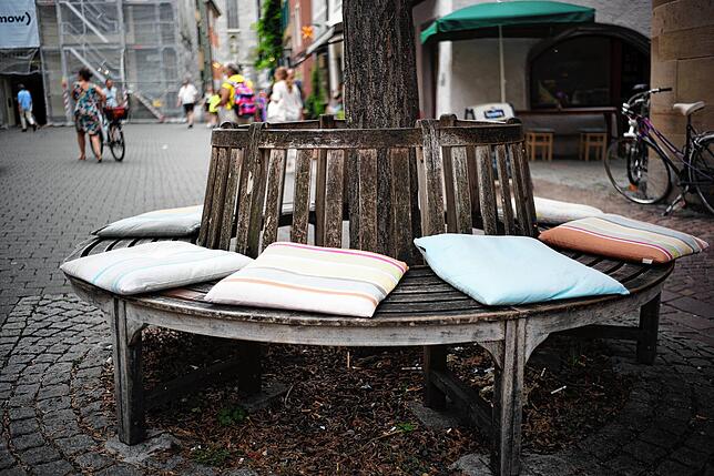 Zollenstraße, kostenlos: Rund um den Baum gibt es eine schöne Sitzbank, sogar mit Kissen. Die Geschäftsleute hier wollen es auch jenen ...
