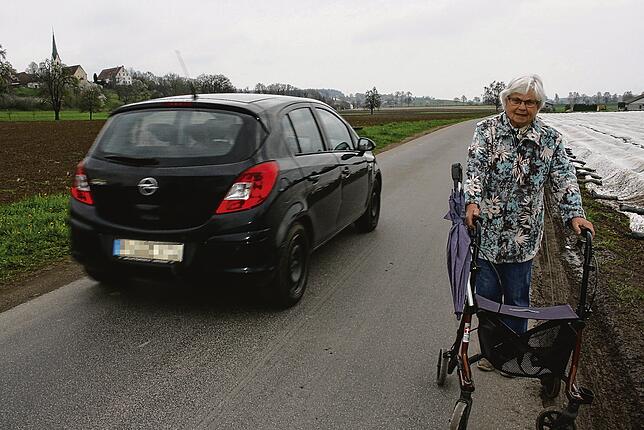 Eine Fußgängerin drückt sich an die Seite, wenn ihr auf einem Spazierweg verbotenerweise ein Auto entgegenkommt. Bild: Peter Schober