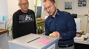 Hauptamtsleiter Sebastian Duffner (rechts) öffnet am Montagmorgen im Rathaus das Siegel an einer Wahlurne für die Gemeinderatswahl in ...
