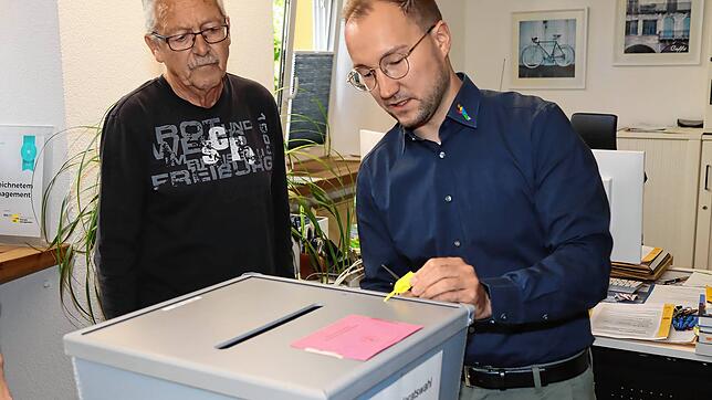 Hauptamtsleiter Sebastian Duffner (rechts) öffnet am Montagmorgen im Rathaus das Siegel an einer Wahlurne für die Gemeinderatswahl in ...