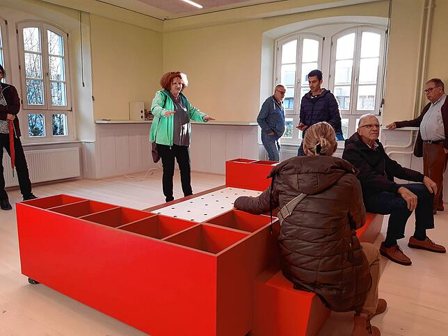 Kulturamtsleiterin Kerstin Simon (hinten) zeigt im Bereich der Kinderbücher eine Sitzgelegenheit kombiniert mit einem Bücherregal.