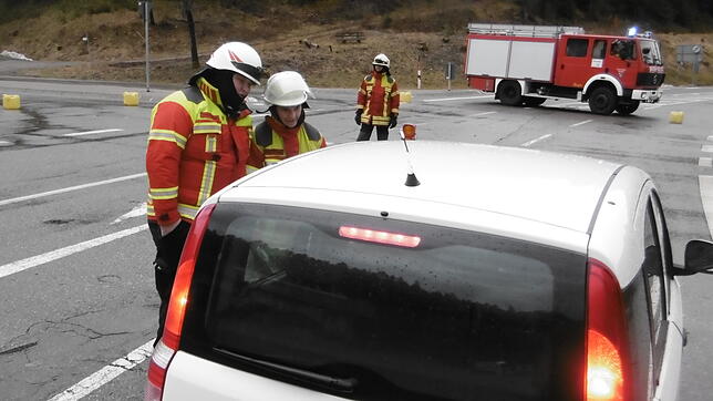 Feuerwehrleute sprechen mit einem Autofahrer an einer Straßensperre im Oberen Bregtal an der Kreuzung Richtung ...