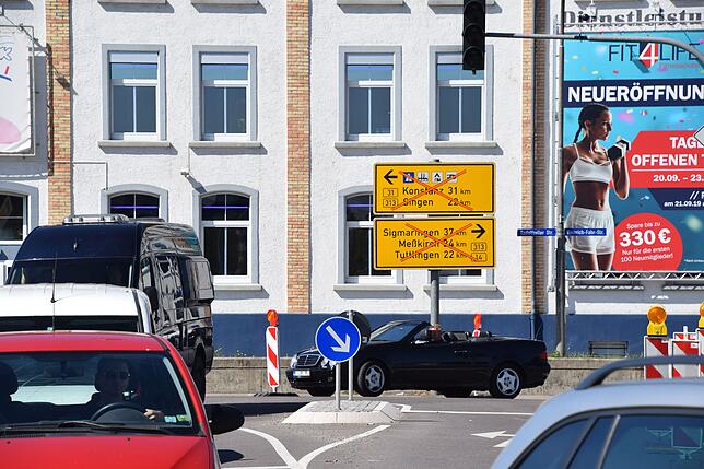 Das Schild zeigt die Sperrungen an. Von rechts kommt umgeleiteter Verkehr aus Richtung Nellenburgstraße zum Schiesser-Knoten, der offen ist.