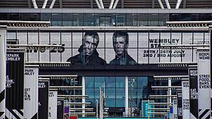Auf den Bildschirmen im Wembley-Stadion wird für die bevorstehenden Auftritte von Oasis geworben. (Archivbild)