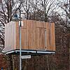 In luftiger Höhe schwebt das erste Bauteil , transportiert von einem Kran.