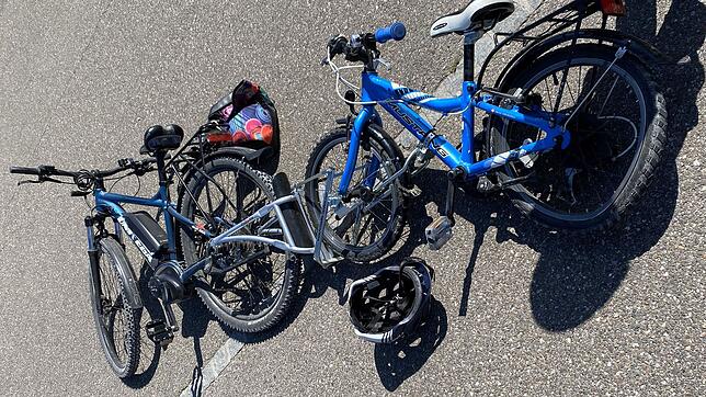 Ein kaputtes Fahrrad und ein Helm liegen nach einem Unfall auf der Straße. (Symbolbild) Bei einem Unfall in der Badstraße in ...