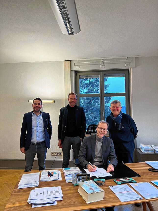 Mathias Tonigold, Achim Niess und Herrmann Schmeißer (von links) bei Notar Ralf Merschformann (sitzend).