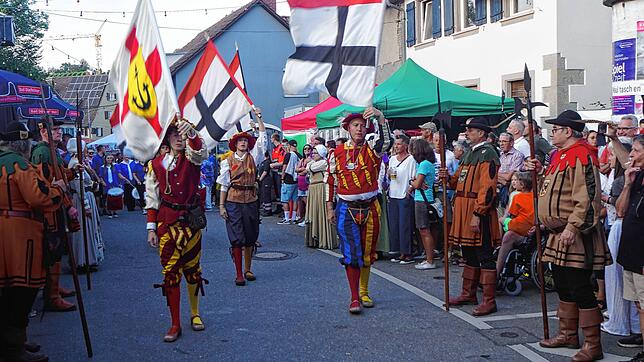 Die Fahnenschwinger der Freien Blätz ziehen ein auf dem Wollmatinger Dorffest mit Konstanzer und Wollmatinger Fahnen.