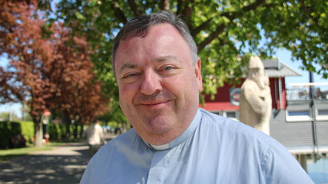 Stadtpfarrer Michael Hauser auf der Mole vor der Skulptur des Stadtgründers Bischof Radolt von Verona: An dieser Stelle empfängt der ...